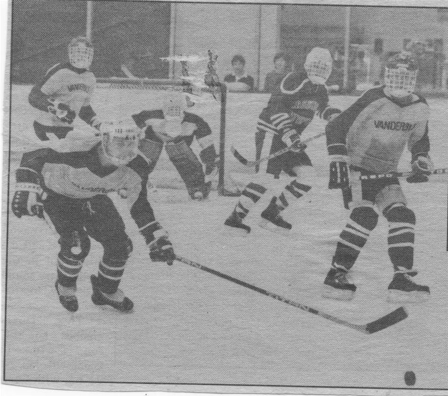 Robbie Chura can be seen on the left, bent over while chasing the puck.
