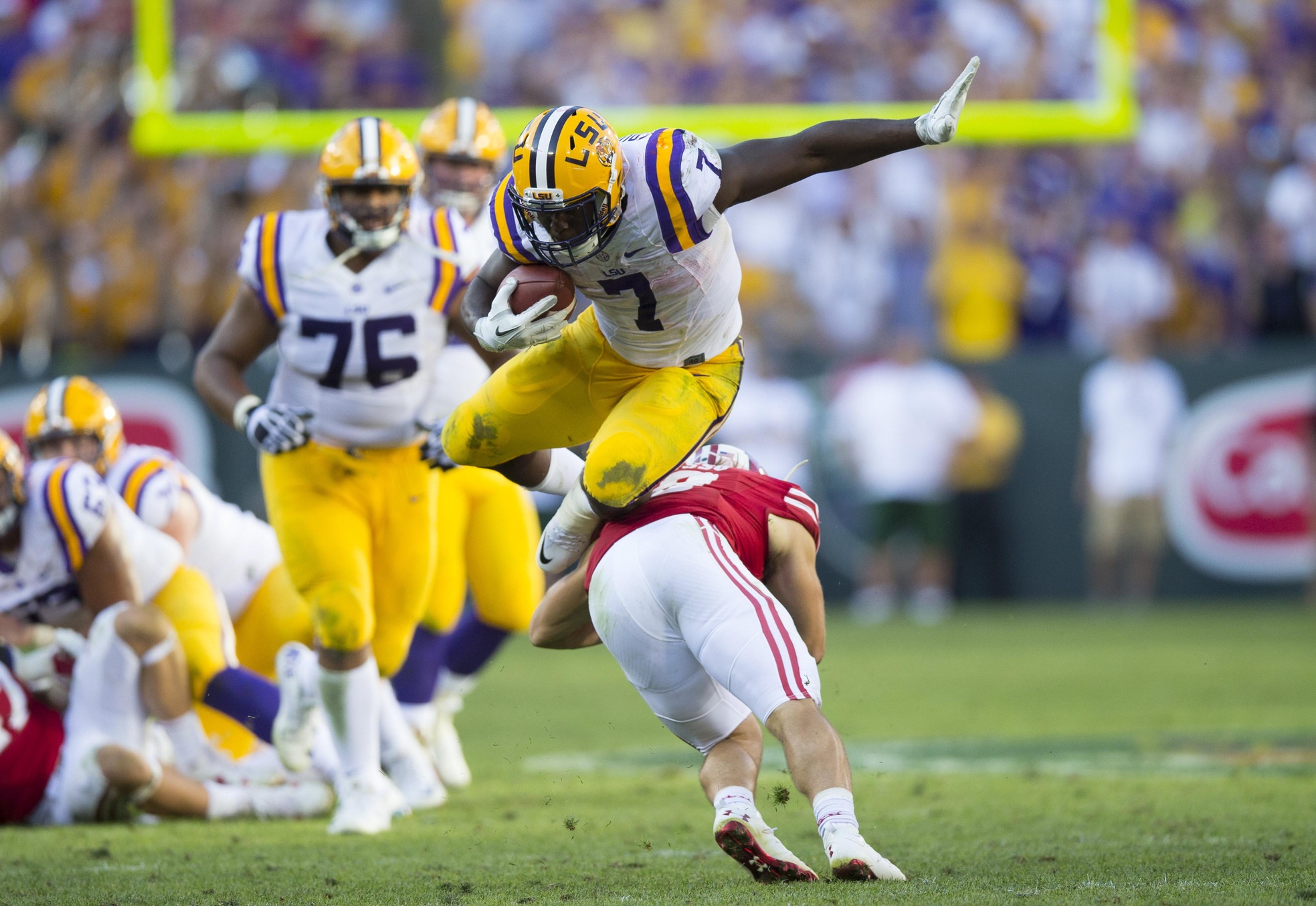 Sep 3, 2016; Green Bay, WI, USA; LSU Tigers running back Leonard Fournette (7) leaps over Wisconsin Badgers safety Leo Musso (19) during the fourth quarter at Lambeau Field. Mandatory Credit: Jeff Hanisch-USA TODAY Sports