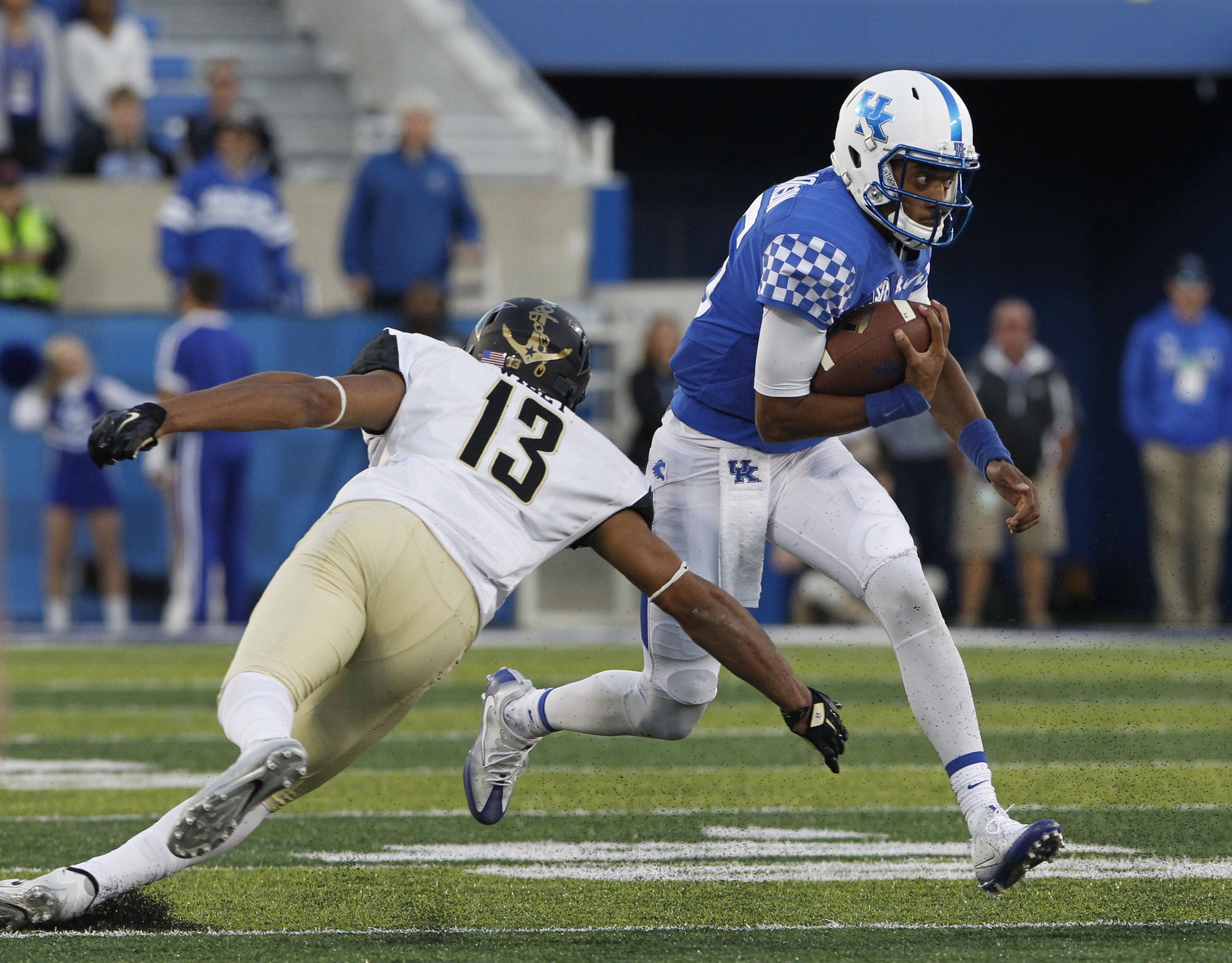 Oct 8, 2016; Lexington, KY, USA; Kentucky Wildcats quarterback Stephen Johnson (15) runs the ball against Vanderbilt Commodores safety LaDarius Wiley (13) in the second half at Commonwealth Stadium. Kentucky defeated Vanderbilt 20-13. Mandatory Credit: Mark Zerof-USA TODAY Sports