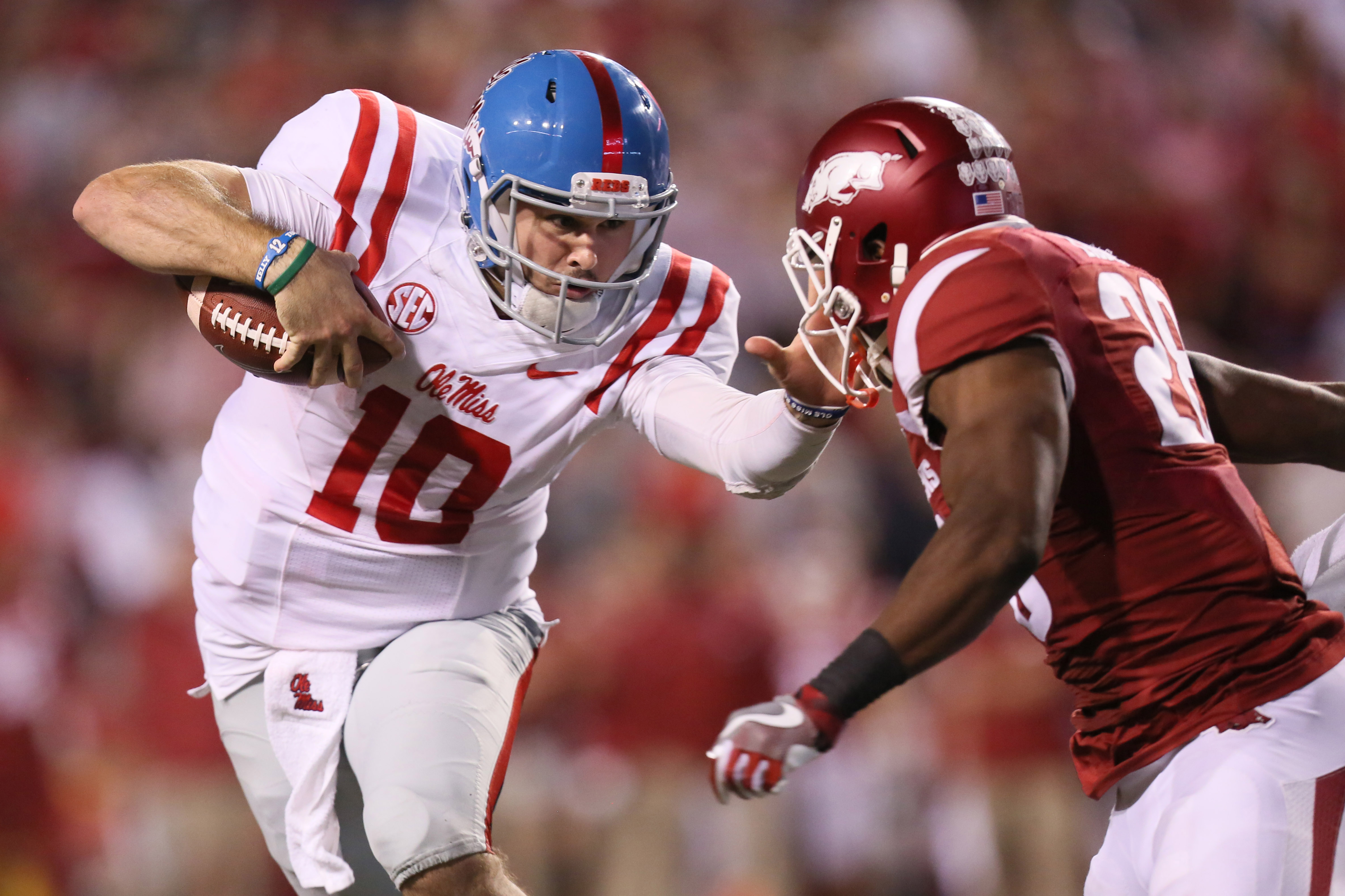 Oct 15, 2016; Fayetteville, AR, USA; Ole Miss Rebels quarterback Chad Kelly (10) pushes off of Arkansas Razorbacks defensive back Josh Lidddell (28) during the second half at Donald W. Reynolds Razorback Stadium. Arkansas defeated Ole Miss 34-30. Mandatory Credit: Nelson Chenault-USA TODAY Sports