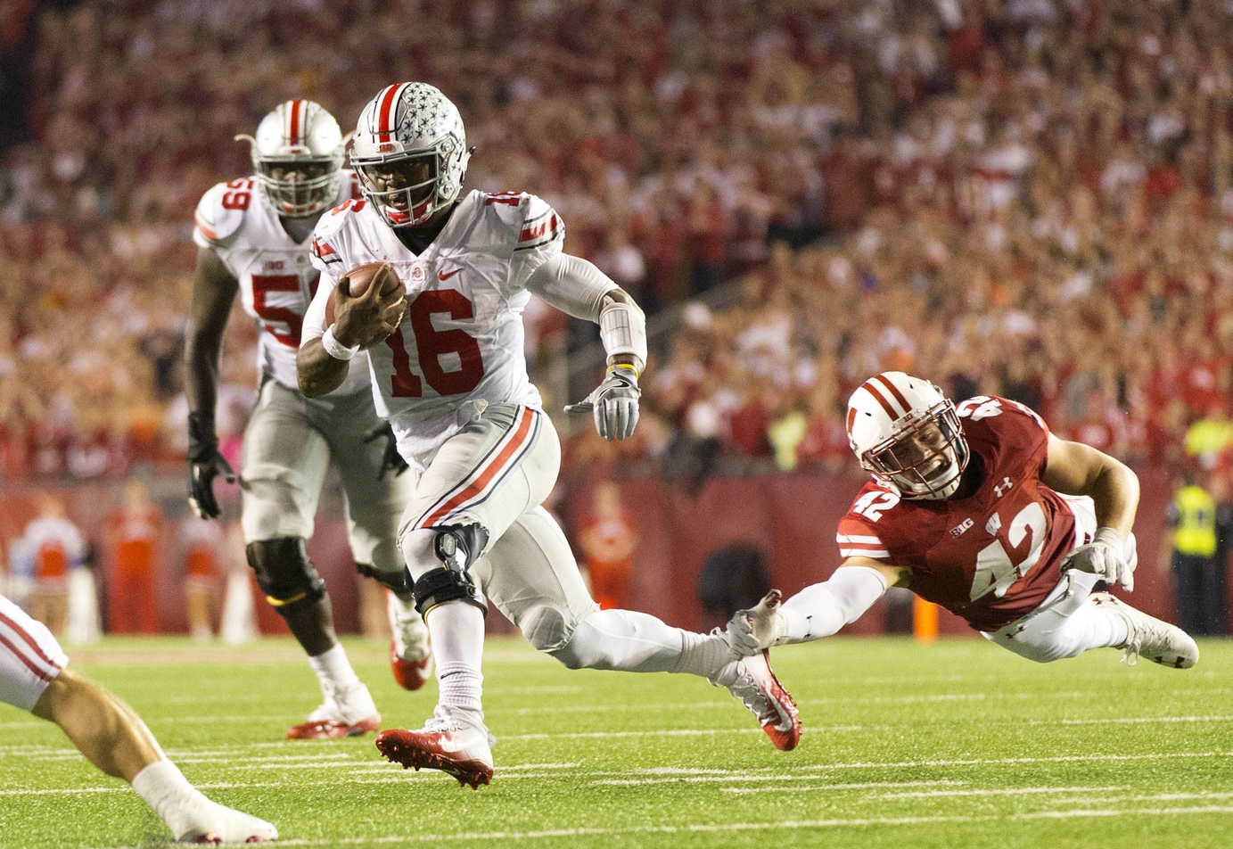 Oct 15, 2016; Madison, WI, USA; Ohio State Buckeyes quarterback J.T.  Barrett (16) rushes with the football as Wisconsin Badgers linebacker <a rel=