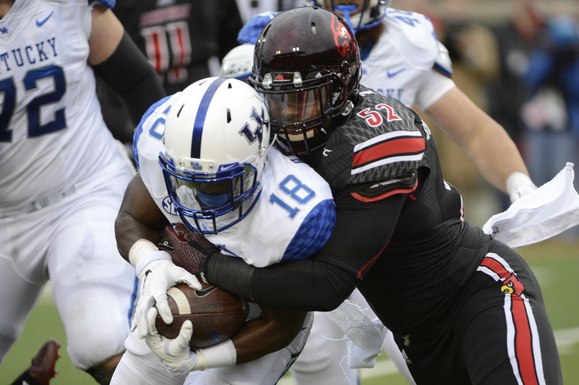 Nov 29, 2014; Louisville, KY, USA; Kentucky Wildcats running back Stanley Williams (18) breaks the tackle of Louisville Cardinals linebacker Nick Dawson-Brents (52) to score a touchdown during the second half at Papa John's Cardinal Stadium. Louisville defeated Kentucky 44-40. Mandatory Credit: Jamie Rhodes-USA TODAY Sports