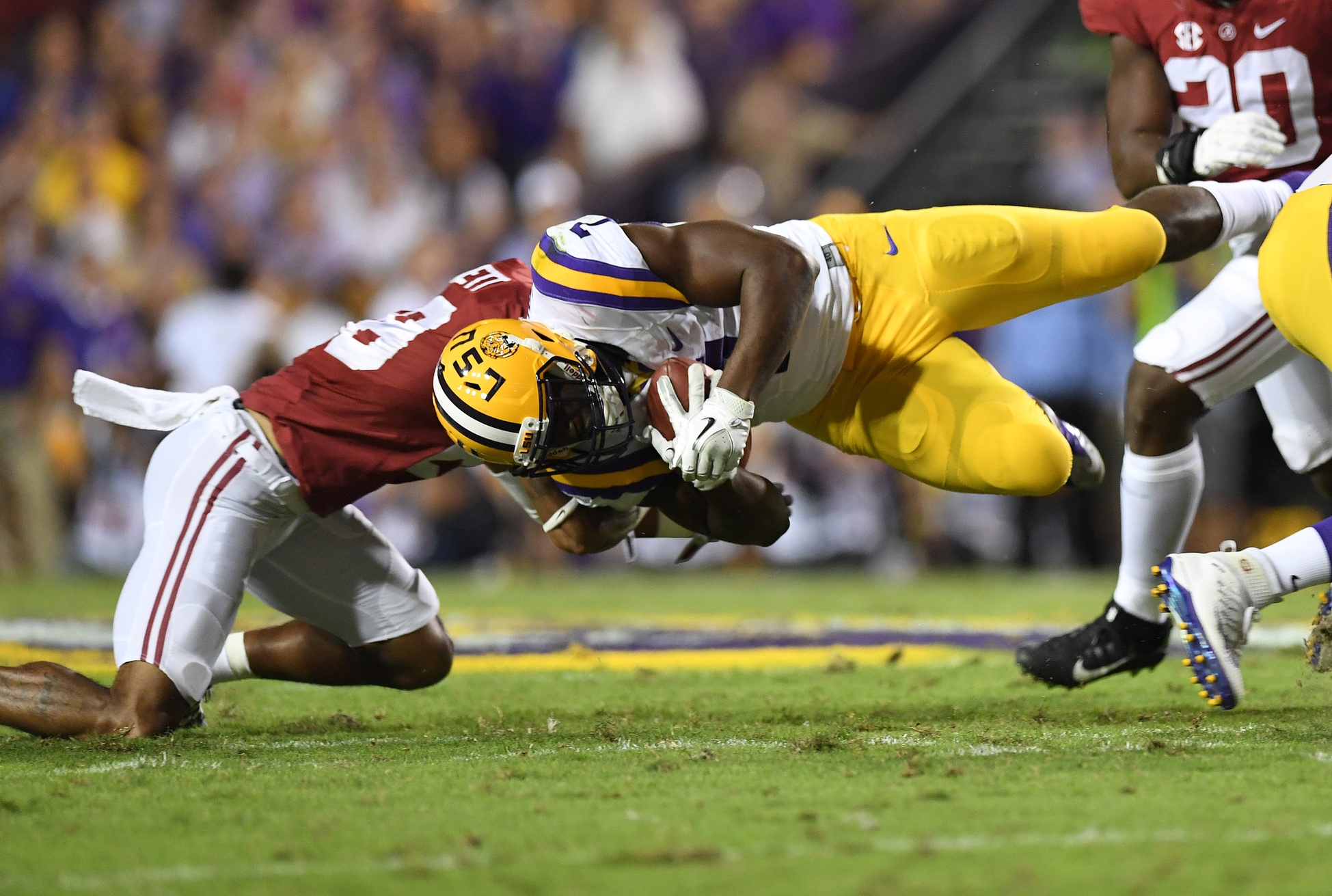 Nov 5, 2016; Baton Rouge, LA, USA; LSU Tigers running back Leonard Fournette (7) dives for extra yardage against Alabama Crimson Tide defensive back Anthony Averett (28) during the second quarter at Tiger Stadium. Mandatory Credit: John David Mercer-USA TODAY Sports