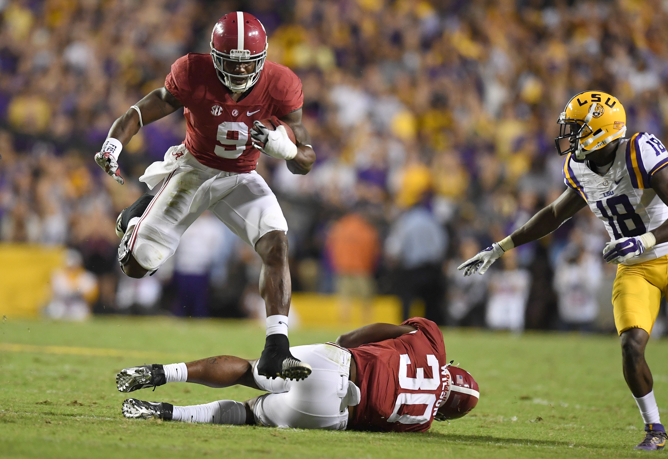 Nov 5, 2016; Baton Rouge, LA, USA; Alabama Crimson Tide running back Bo Scarbrough (9) leaps over a teammate as he scrambles up the field against the LSU Tigers during the third quarter at Tiger Stadium. Alabama defeated LSU 10-0. Mandatory Credit: John David Mercer-USA TODAY Sports