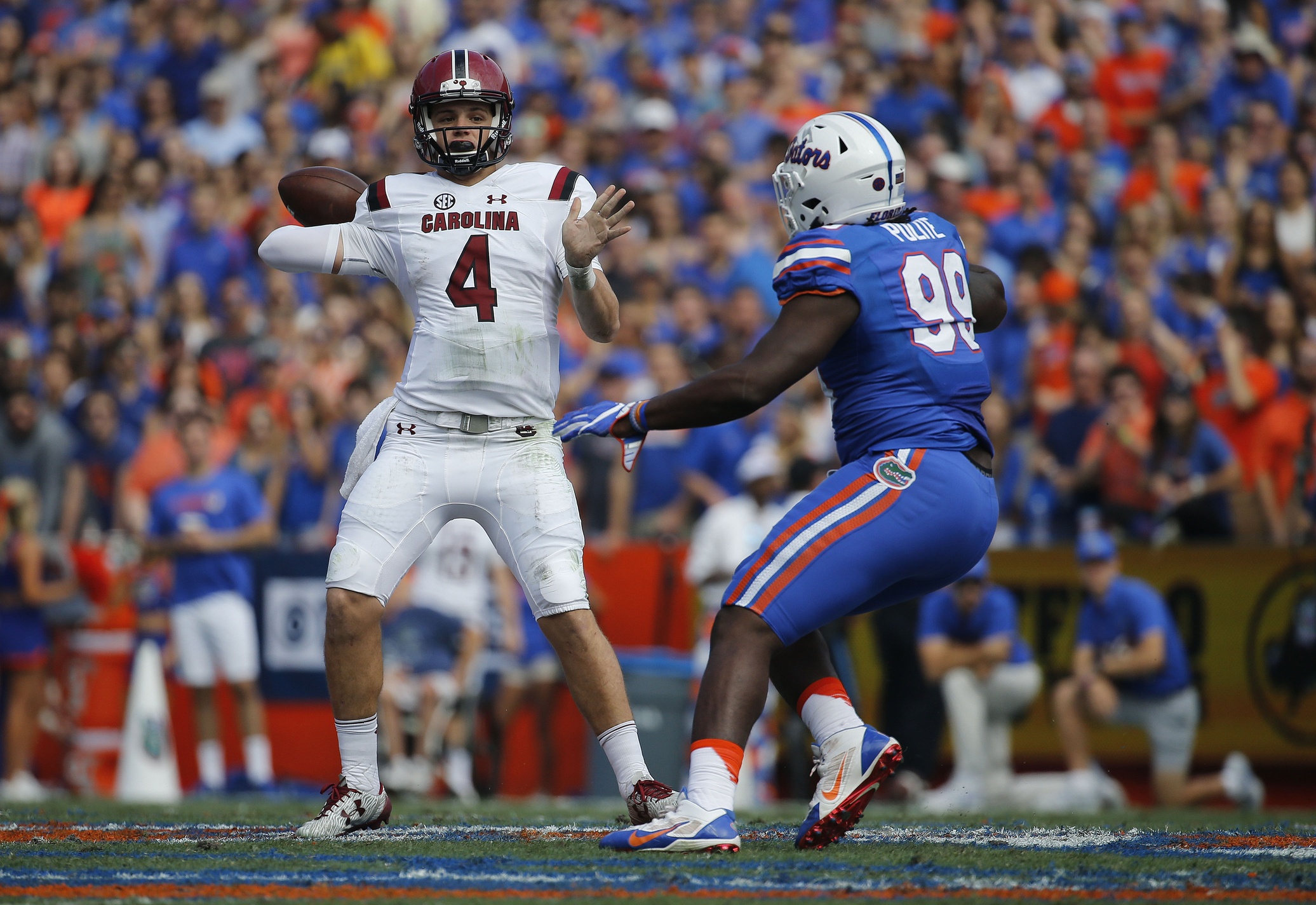Nov 12, 2016; Gainesville, FL, USA; South Carolina Gamecocks quarterback Jake Bentley (4) throws the ball as Florida Gators defensive lineman Jachai Polite (99) defends during the first quarter at Ben Hill Griffin Stadium. Mandatory Credit: Kim Klement-USA TODAY Sports