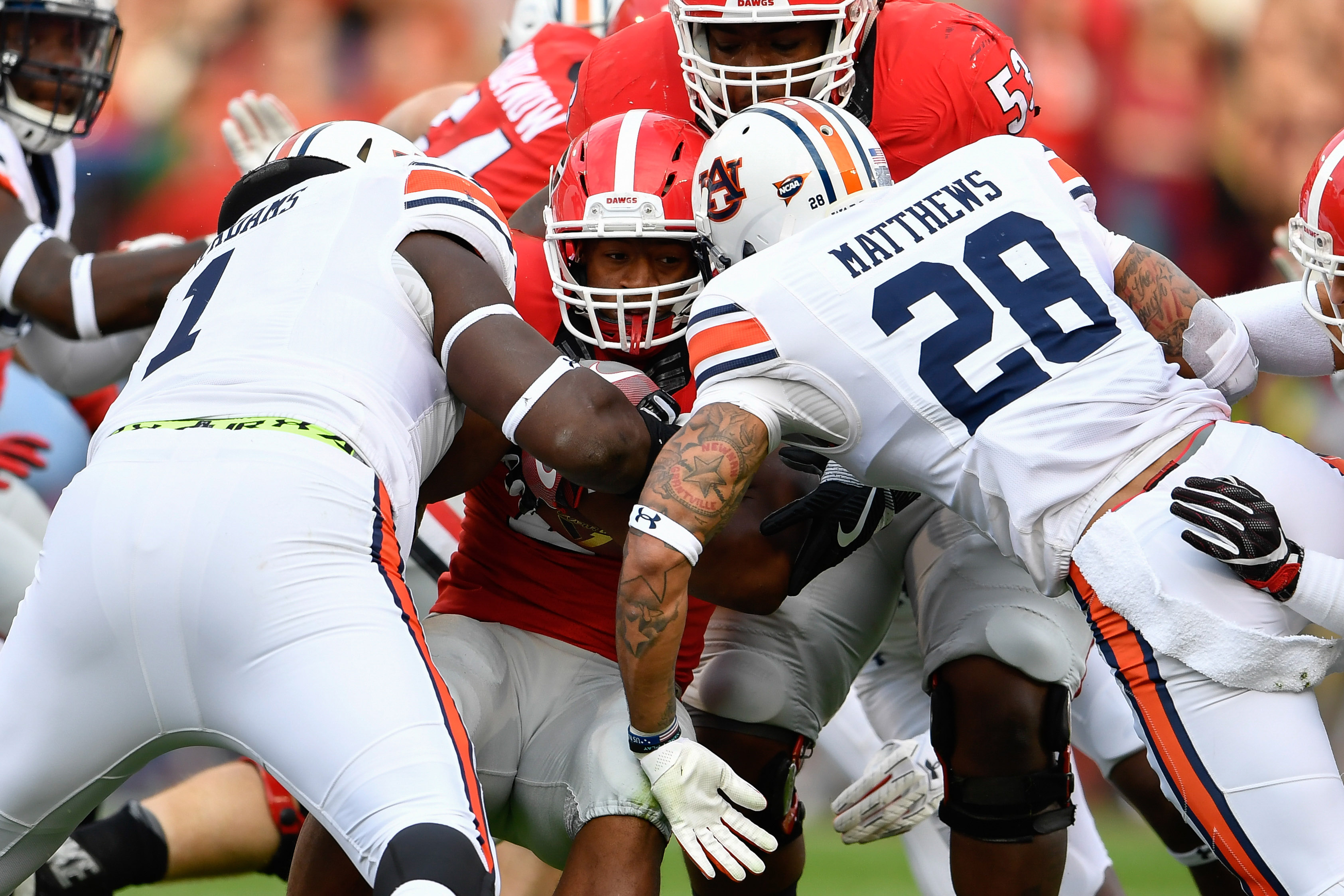 Nov 12, 2016; Athens, GA, USA; Georgia Bulldogs running back Nick Chubb (27) tackled by Auburn Tigers defensive tackle Montravius Adams (1) and defensive back Tray Matthews (28) during the first quarter at Sanford Stadium. Mandatory Credit: Dale Zanine-USA TODAY Sports