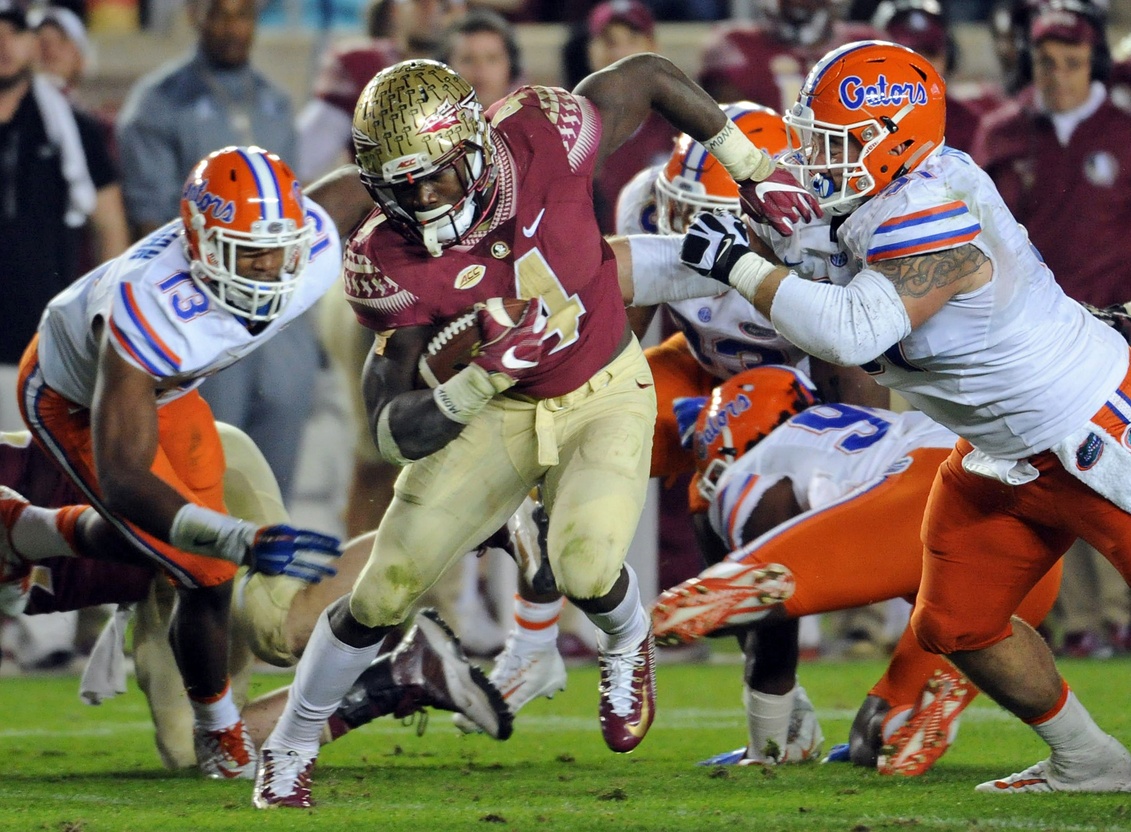 Nov 26, 2016; Tallahassee, FL, USA; Florida State Seminoles running back Dalvin Cook (4) runs the ball past Florida Gators defenders during the second half of the game at Doak Campbell Stadium. Mandatory Credit: Melina Vastola-USA TODAY Sports