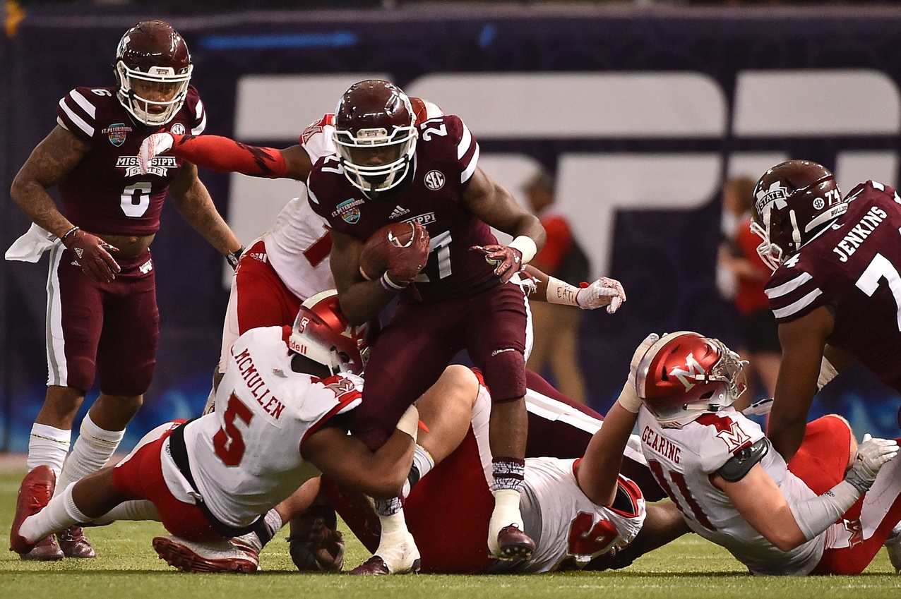 Dec 26, 2016; St. Petersburg, FL, USA; Miami Redhawks defensive back Tony Reid (14) and Miami Redhawks linebacker Junior McMullen (5) bring down Mississippi State Bulldogs running back Aeris Williams (27) during the first half at Tropicana Field. Mandatory Credit: Jasen Vinlove-USA TODAY Sports