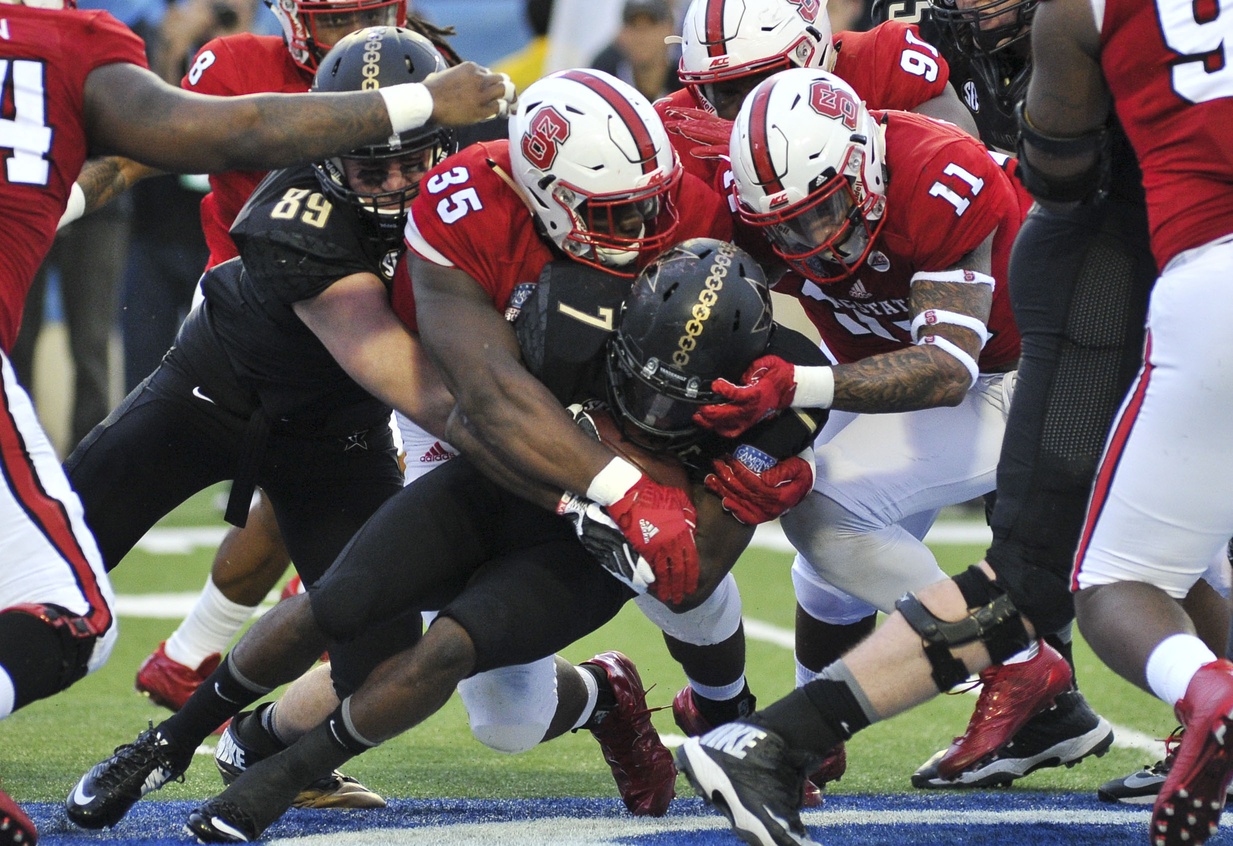 Dec 26, 2016; Shreveport, LA, USA; North Carolina State Wolfpack defensive end Kentavius Street (35) and North Carolina State Wolfpack safety Josh Jones (11) tackle Vanderbilt Commodores running back Ralph Webb (7) during the first half at Independence Stadium. Mandatory Credit: Justin Ford-USA TODAY Sports