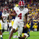 Alabama quarterback Jalen Milroe carries the ball against Michigan in a College Football Playoff game.