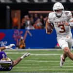 Texas quarterback Quinn Ewers carries the ball against Washington in a College Football Playoff matchup.