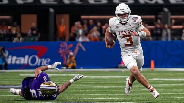 Texas quarterback Quinn Ewers carries the ball against Washington in a College Football Playoff matchup.