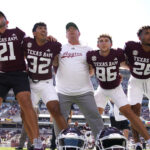 Texas A&M players and Mike Elko after a game.