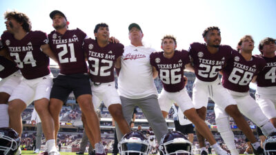 Texas A&M players and Mike Elko after a game.