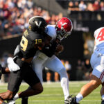 Jalen Milroe gets tackled by a Vanderbilt player.