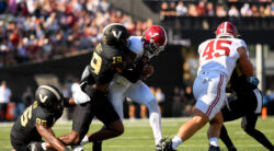 Jalen Milroe gets tackled by a Vanderbilt player.