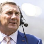 Dan Mullen wears a headset.