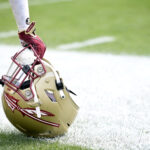 An image of an FSU player and his helmet on the sidelines.
