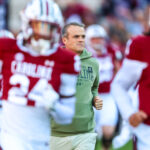 Shane Beamer runs onto the field with his team.
