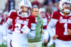 Shane Beamer runs onto the field with his team.
