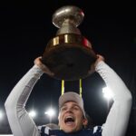 Walker Howard hoists the Golden Egg after Ole Miss beats Mississippi State.