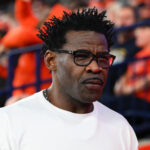 Michael Irvin is shown on the sidelines.