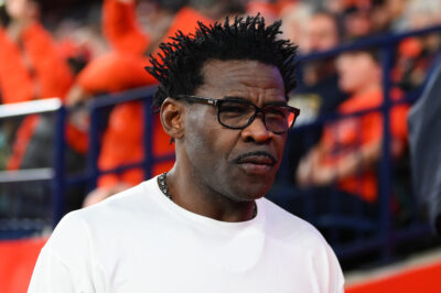 Michael Irvin is shown on the sidelines.