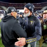 Navy coach Brian Newberry shakes hands with Army coach Jeff Monken.