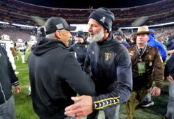 Navy coach Brian Newberry shakes hands with Army coach Jeff Monken.