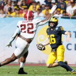 Davis Warren scrambles for Michigan with Alabama's LT Overton in pursuit.