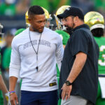 Notre Dame coach Marcus Freeman and Ohio State coach Ryan Day talk before a game in 2023.