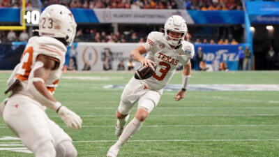 Quinn Ewers carries the ball in Texas's CFP quarterfinal game.