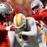 Tennessee quarterback Nico Iamaleava gets tackled by Ohio State defenders.