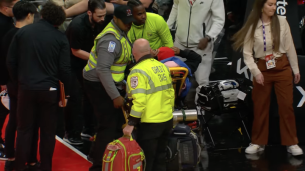 An Atlanta Hawks fan is stretchered off the court.