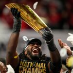 Jeremiah Smith of Ohio State hoists the national championship trophy.