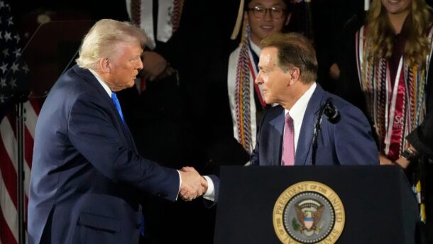 Donald Trump and Nick Saban shake hands.