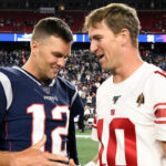 Tom Brady and Eli Manning shake hands.