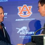 Hugh Freeze and John Cohen at a press conference.