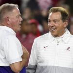 Brian Kelly and Nick Saban talk before a game.