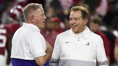 Brian Kelly and Nick Saban talk before a game.