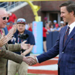 Archie Manning shakes Eli Manning's hand.