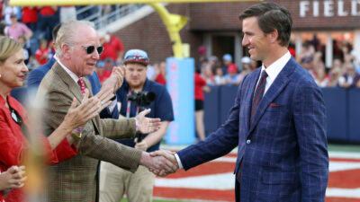 Archie Manning shakes Eli Manning's hand.