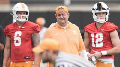Josh Heupel stands next to Jake Merklinger and Joey Aguilar.