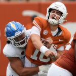 Texas quarterback Arch Manning gets hit.