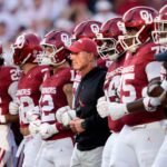 Oklahoma football players and coach Brent Venables before a game.