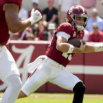 Ty Simpson runs with the ball.