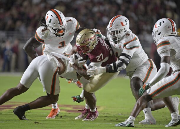 Miami's defense swallows up a Florida State player.