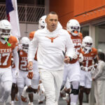 Steve Sarkisian leads the Texas Longhorns out of the tunnel.