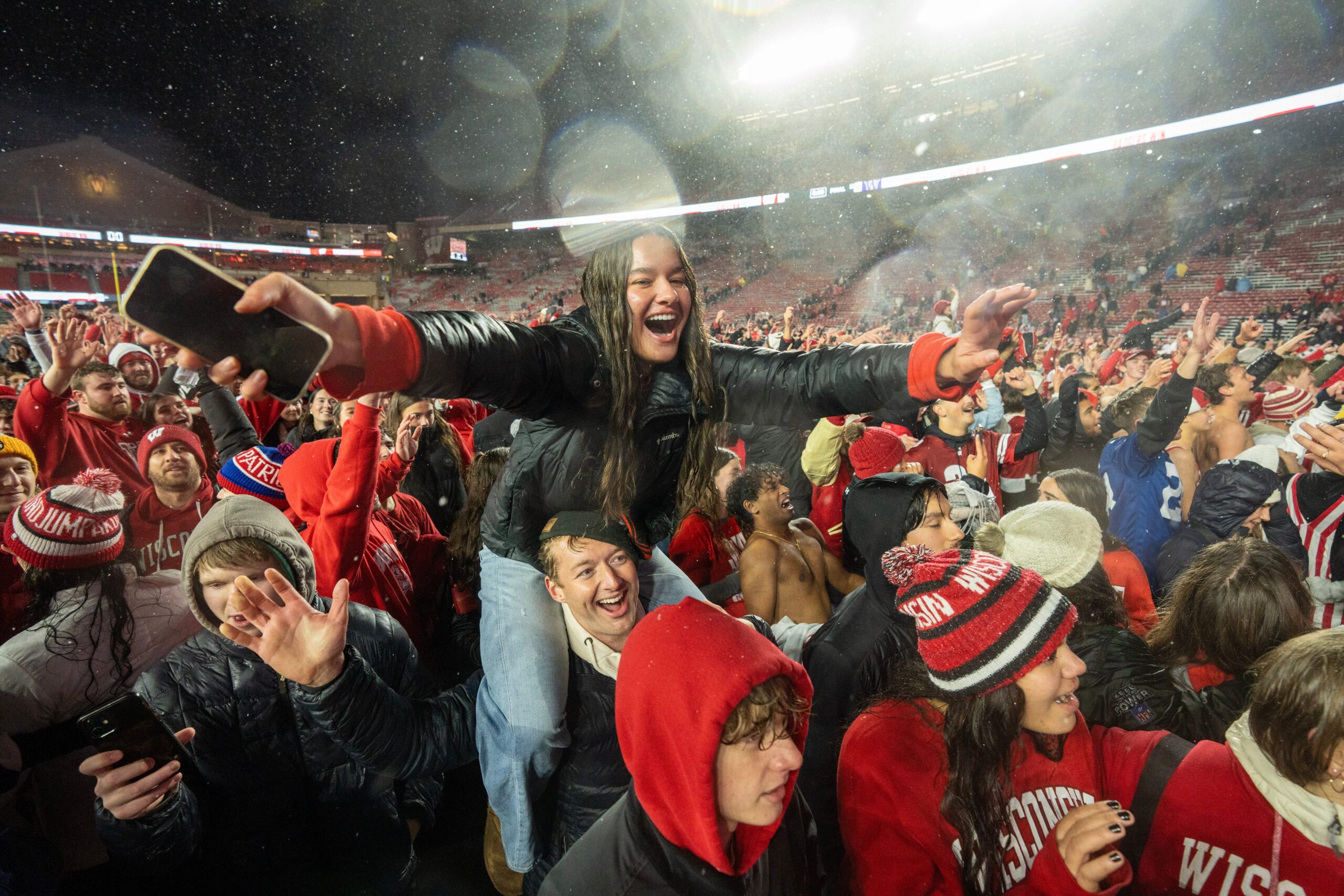 Wisconsin fans storm the field after upsetting No. 23 Washington in the pouring rain