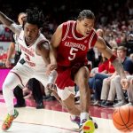 Darius Acuff Jr. of Arkansas battles an Alabama player for a loose ball.
